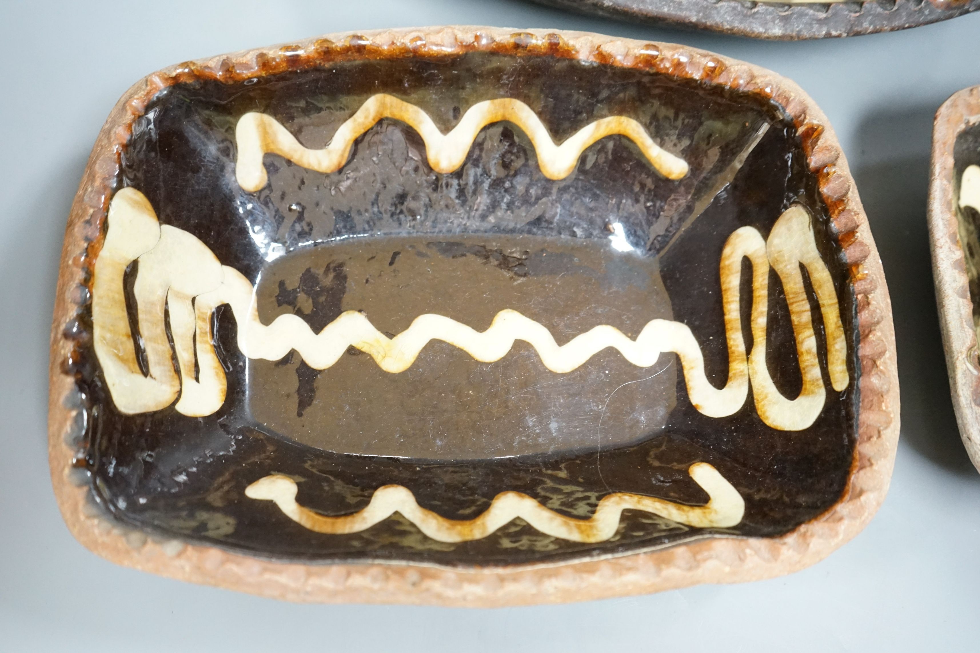 Winchcombe pottery, three press moulded slipware dishes, one with Ray Finch maker’s stamp, largest 26.5cm wide